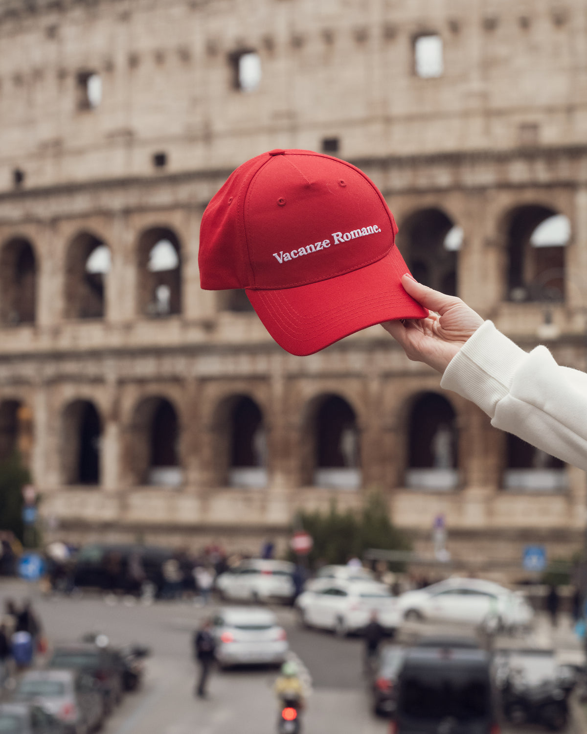 Czerwona czapka baseball cap z haftem Vacanze Romane. Vacanze Romane (Rzymskie wakacje) to kultowy film z Audrey Hepburn w roli głównej. 