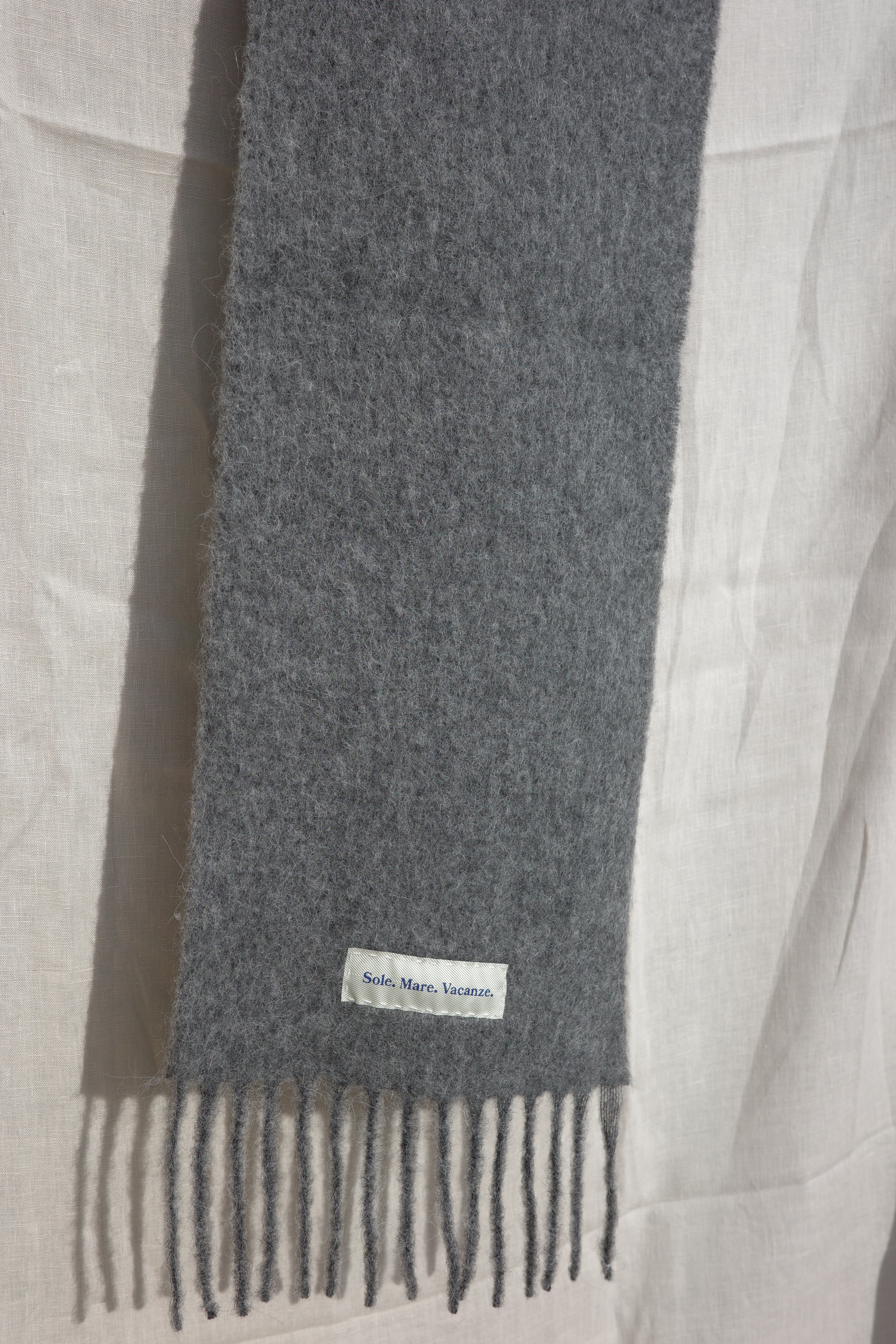 Sole Mare Vacanze szalik szary – luksusowy, włoski produkt, naturalny materiał, subtelny odcień szarości.
Grey alpaca-wool scarf – unisex, lightweight and warm, perfect for casual and elegant outfits.
